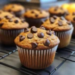 Freshly baked chocolate chip pumpkin muffins on a wooden table