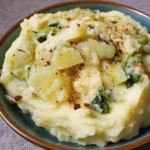Creamy mashed potatoes topped with sautéed cabbage in a bowl