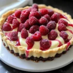 Creamy white chocolate raspberry tart garnished with fresh raspberries