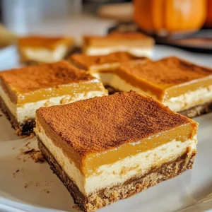 Delicious pumpkin cheesecake bars topped with whipped cream and spices.