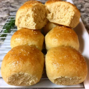 Gluten-free vegan dinner rolls on a wooden table with herbs