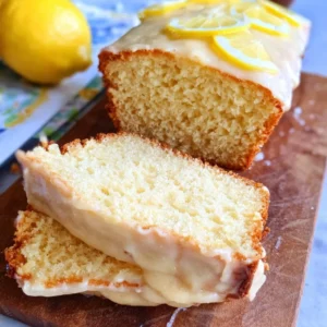 Gluten-free vegan lemon bread slice on a plate with lemon slices