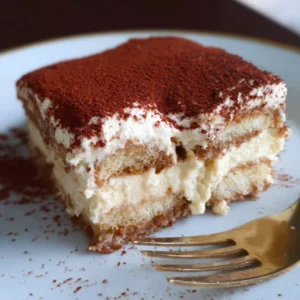 Gluten-free vegan tiramisu dessert served on a plate with cocoa powder on top