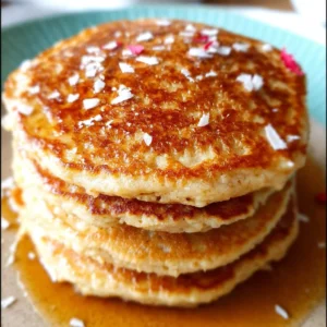 Plate of fluffy oat flour pancakes topped with fresh berries and syrup