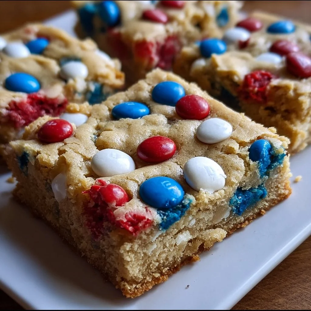 Red White and Blue M&M cookie bars on a plate decorated for a festive celebration.