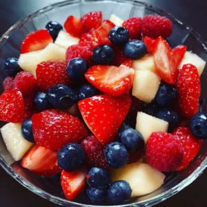 Colorful 4th of July fruit salad served in a bowl with berries and melon.