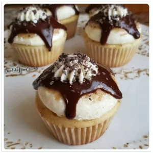 Chocolate Dipped Cannoli Cupcakes topped with chocolate and creamy filling
