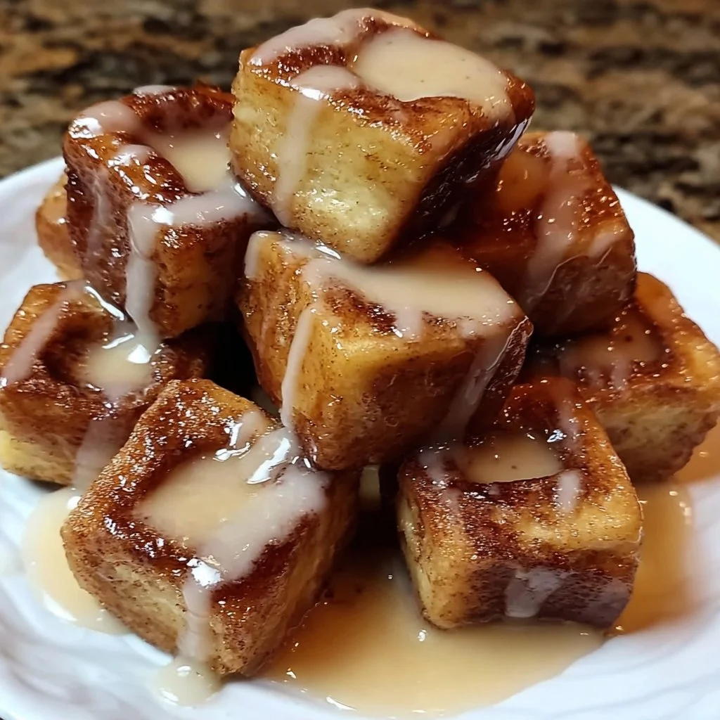 Plate of Cinnamon Roll French Toast Bites with syrup and powdered sugar