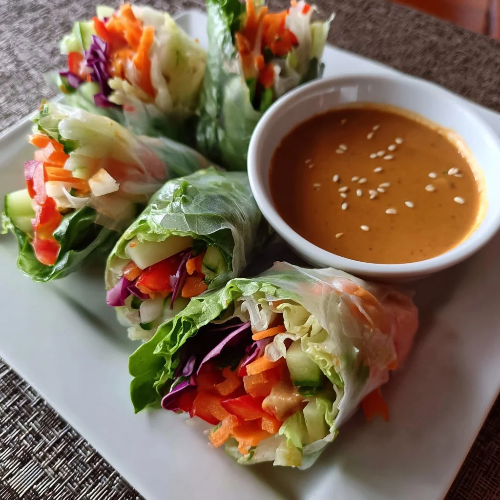 Delicious spring rolls served with peanut sauce on a plate