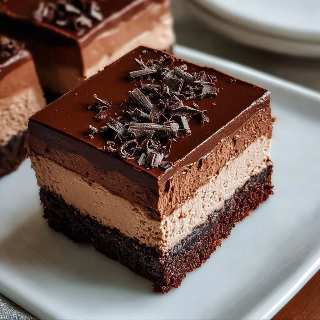 Delicious layered chocolate mousse brownies with a rich chocolate topping.