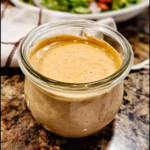 Vegan creamy taco dressing in a glass jar on a rustic table