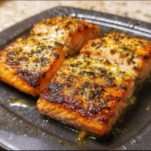 Delicious air fryer salmon served with lemon and herbs on a plate.