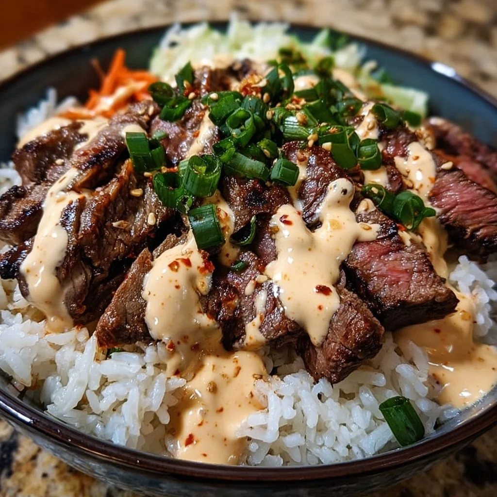 Korean BBQ steak rice bowl with spicy cream sauce, garnished with vegetables.