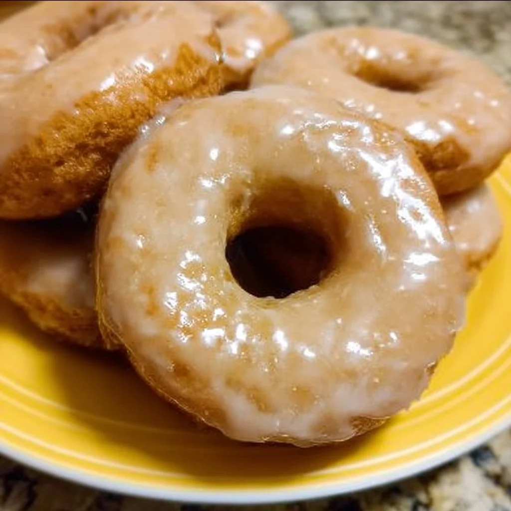 Freshly baked Maple Glazed Donuts topped with rich maple icing