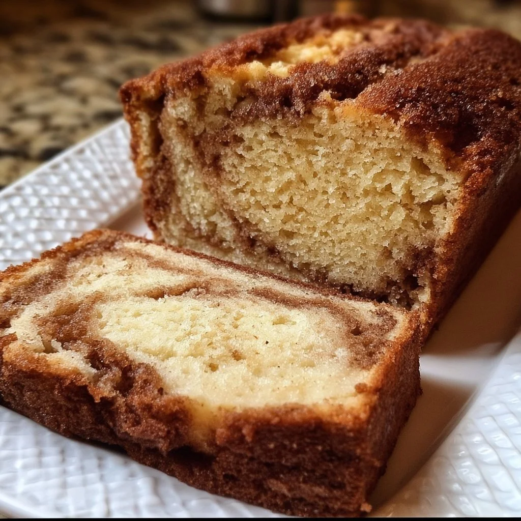 Loaf of freshly baked Amish Cinnamon Bread with a cinnamon swirl and glaze