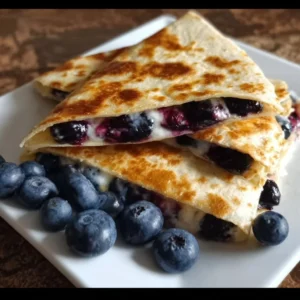 Delicious blueberry breakfast quesadilla on a plate with fresh berries