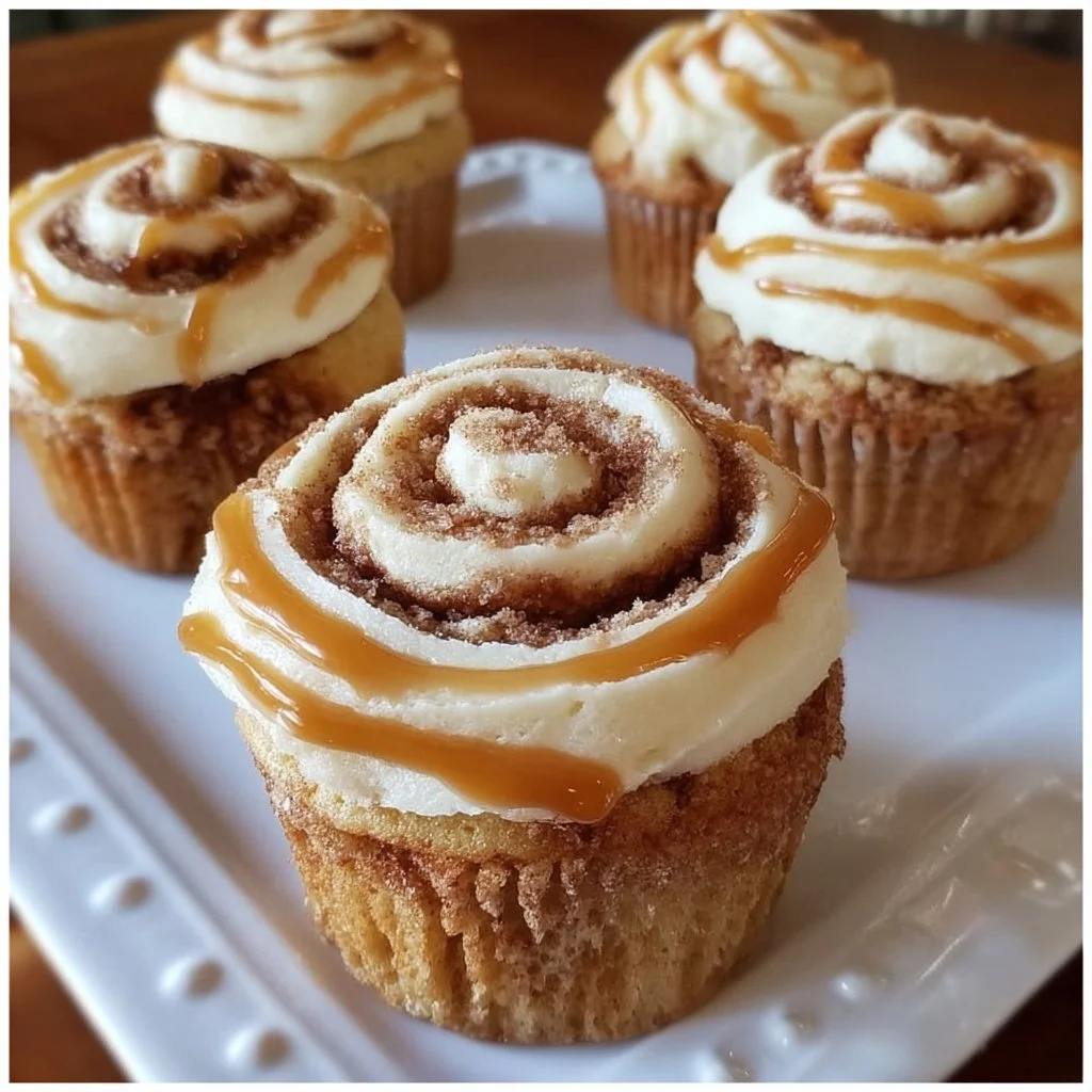Cinnamon roll cupcakes topped with creamy frosting and a sprinkle of cinnamon