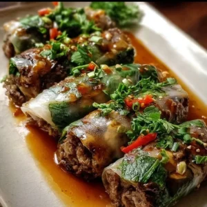 Plate of flavorful Thai Basil Beef Rolls garnished with basil leaves.