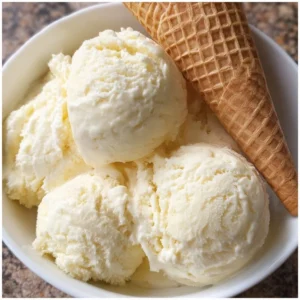 Bowl of dairy-free pina colada ice cream topped with coconut flakes and pineapple chunks