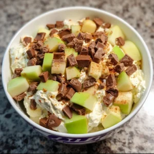 Delicious Snickers apple salad with apples, caramel, and Snickers candy pieces