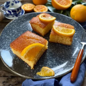 Delicious Honey Orange Snack Cake topped with citrus glaze on a rustic plate