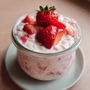 Strawberry overnight oats topped with fresh strawberries and strawberry milk