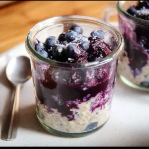 Bowl of blueberry overnight oats topped with fresh blueberries and nuts