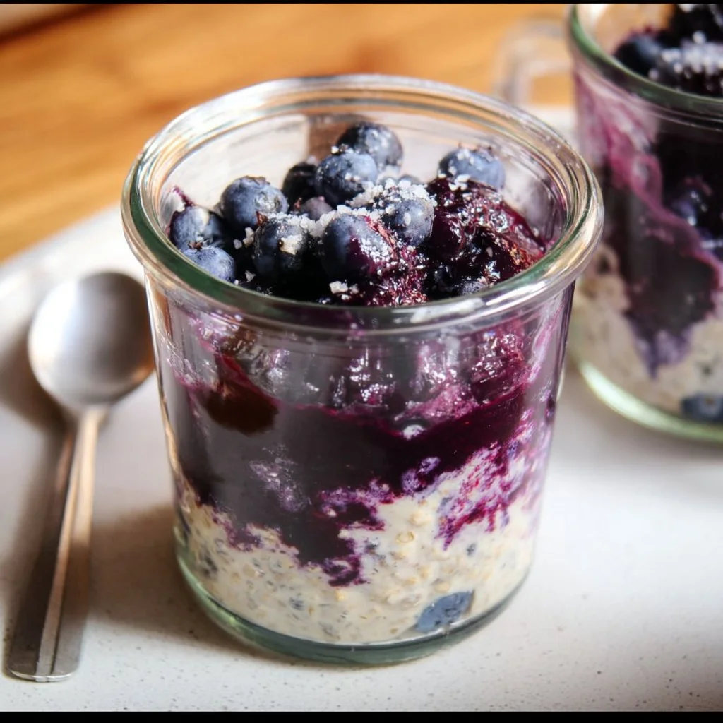 Bowl of blueberry overnight oats topped with fresh blueberries and nuts