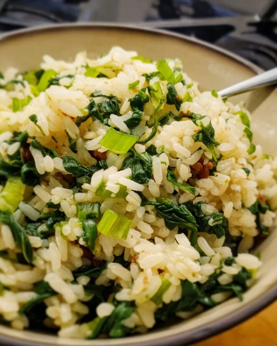 Bowl of Greek spinach rice garnished with herbs and lemon slices