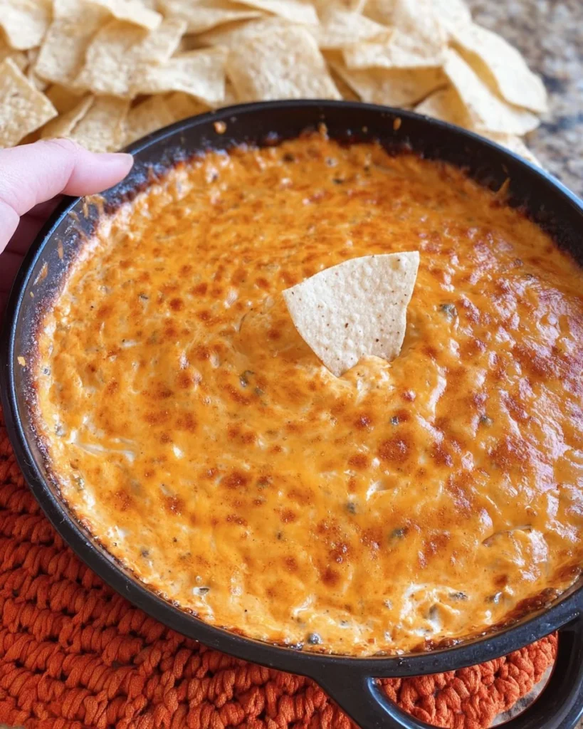 Cheesy bean dip served with tortilla chips and garnished with herbs