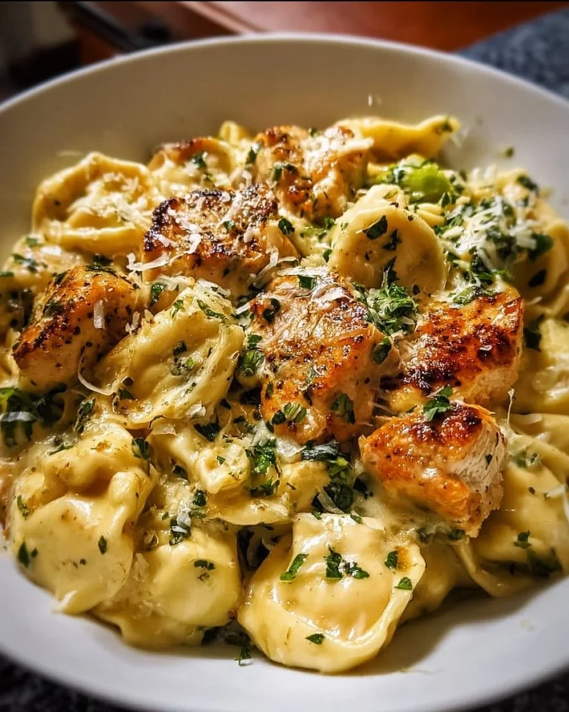 Creamy garlic parmesan chicken tortellini served in a bowl with fresh herbs