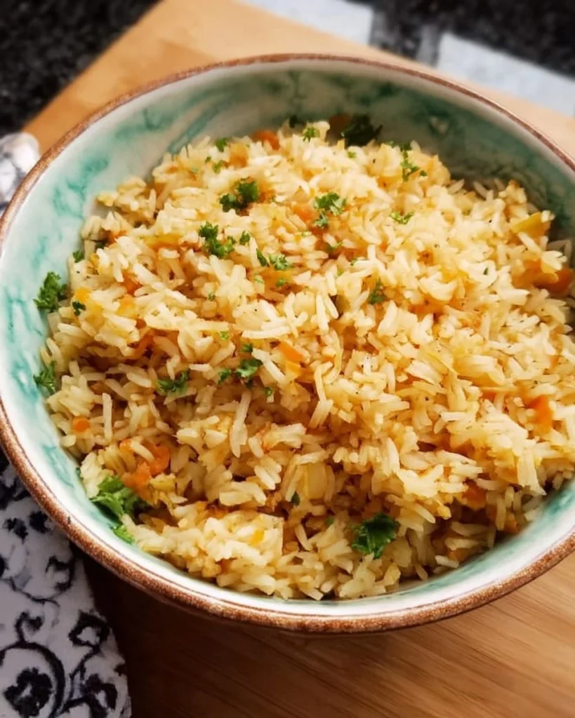 Easy rice pilaf served in a bowl with herbs and vegetables