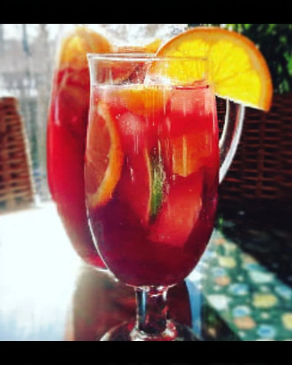 A colorful bowl of non-alcoholic Sangria Punch with fruity garnishes.