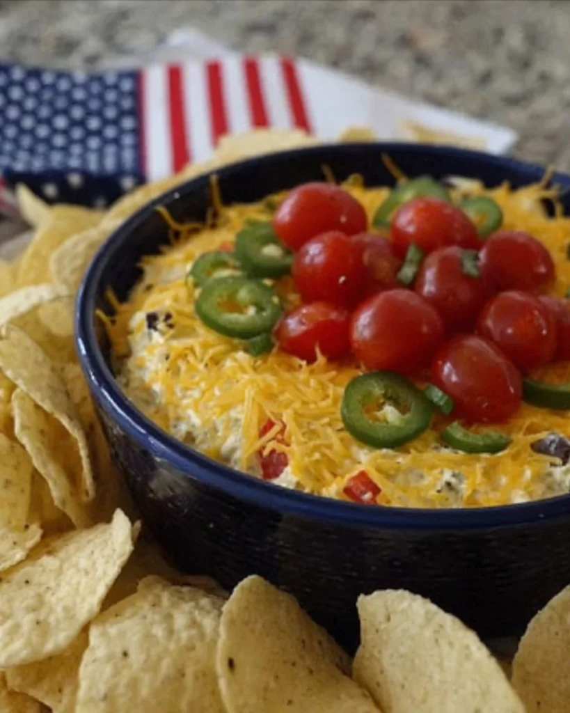 Delicious Taco Salad Dip layered with beans, cheese, and fresh toppings.