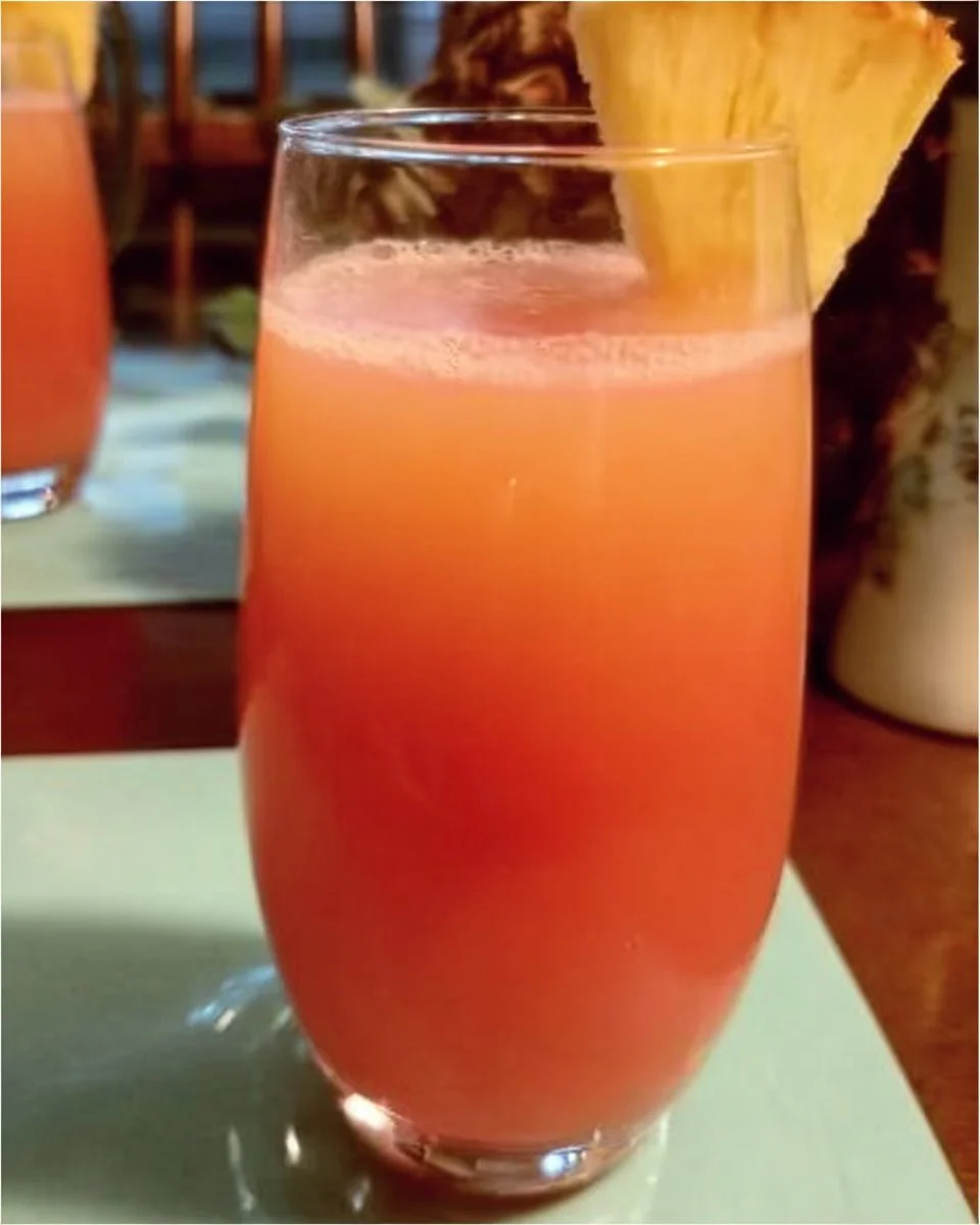 Colorful Caribbean fruit punch in a glass with tropical fruit garnishes