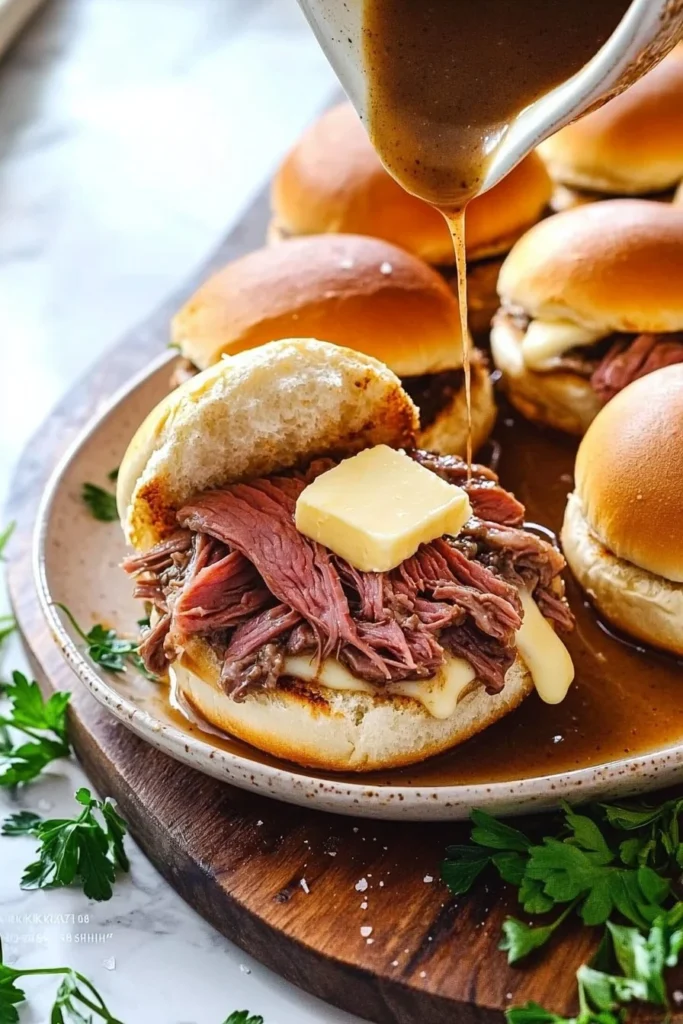 Plate of easy French Dip Sliders served with au jus for dipping