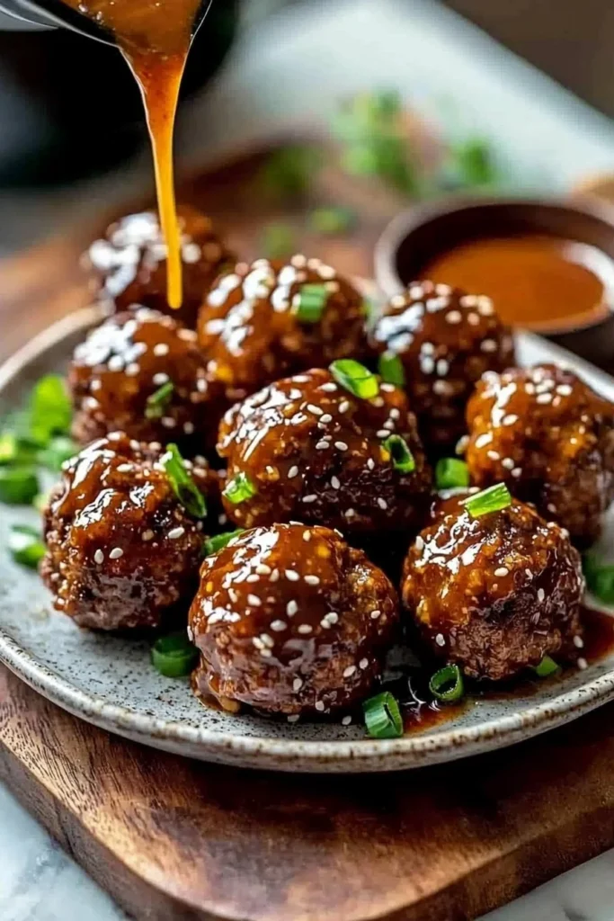 Plate of easy Korean BBQ meatballs garnished with sesame seeds and green onions.