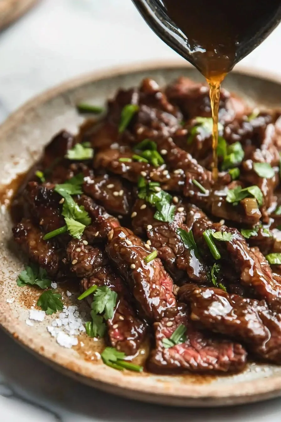 Delicious plate of Mongolian Beef garnished with green onions and served over rice