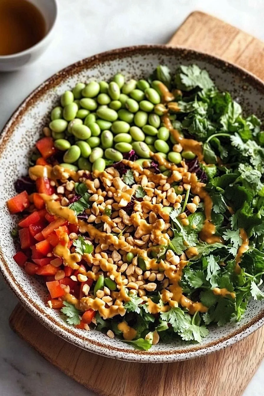A colorful bowl of Edamame Peanut Crunch Salad with fresh vegetables and peanuts.