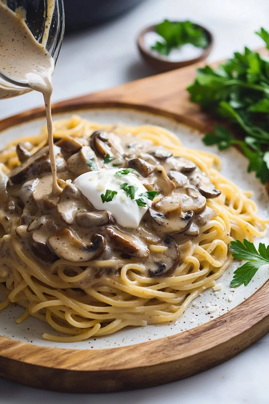 Creamy vegan mushroom stroganoff served in a bowl with herbs on top.