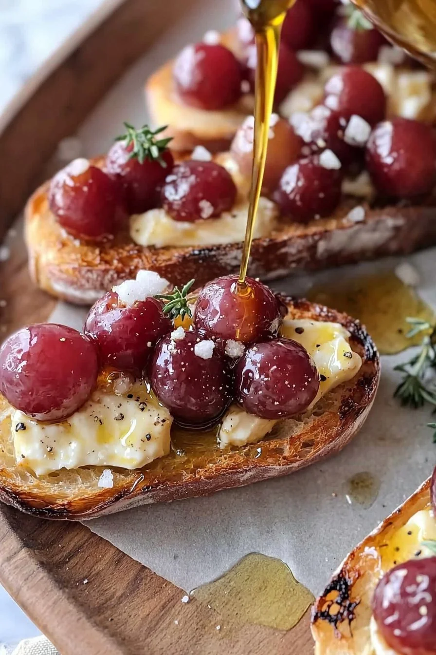 Roasted grape and brie crostini appetizer on a wooden board