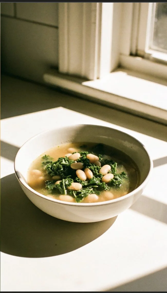 Bowl of kale and white bean soup garnished with fresh herbs