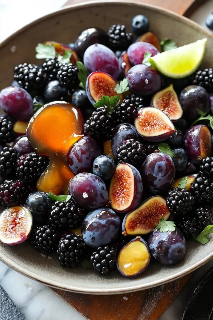 Purple fruit salad with various berries in a bowl.